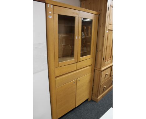 A light oak display cabinet fitted with a drawer 