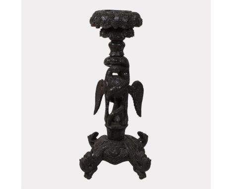 Tall darkhardwood plant stand, caved to depict a snake battling a bird to symbolize the eternal struggle between Garuda and N