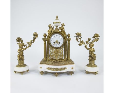 Mantle clock in gilt bronze and white marble, comprising a clock and two candelabras decorated with children and floral vines