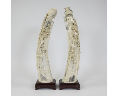 Ivory emperor and empress, bent towards each other in shape of tusk. Both carry a flower branch, decorated with cabochons and