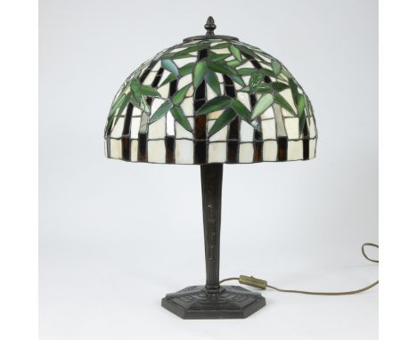 Tiffany-style table lamp, bronze base and shade with decor of leavesTaffellamp in Tiffany stijl, bronzen voet en kap met deco
