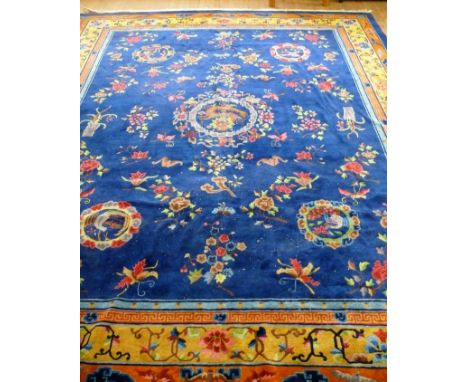 A large Chinese carpet mid 20th CenturyThe predominantly blue ground, the central panel with decoration of butterflies, flowe