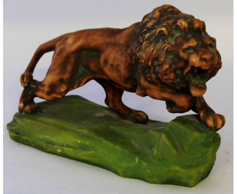 An Amphora model of a lionPerched on a naturalistic rock, impressed and printed factory marks to base, height 24cm, length 33