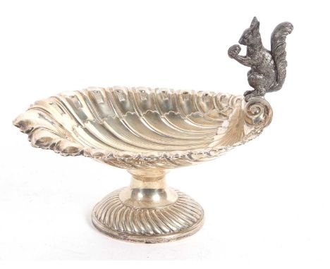 A WMF fruit or nut stand, the scallop shell bowl with a squirrel holding a nut perched on one end, the bowl sits on a fluted 
