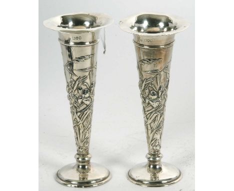 A pair of Edwardian silver trumpet vases, elaborately decorated with flowers, leaves,reeds, etc, loaded bases, 20cm tall, Lon