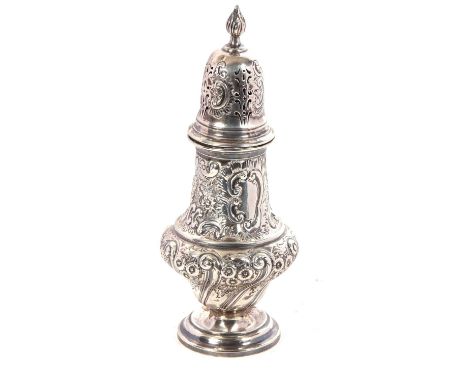 A large late Victorian caster of baluster form with pull off pierced cover with a flame finial, elaborately decorated all ove