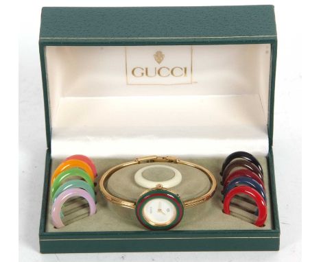 A Gucci 11/12 ladies wristwatch, Quartz movement, white dial with interchangeable coloured bezels, box, card and manual prese