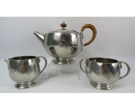 Tudric pewter teaset with hammered finish, Teapot, sugar bowl and milk jug.