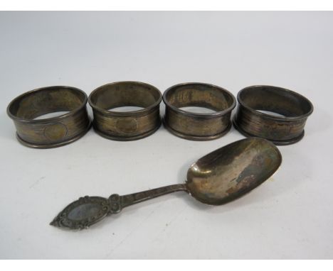 Four sterling silver napkin rings and a caddy spoon, total weight 45.9 grams.