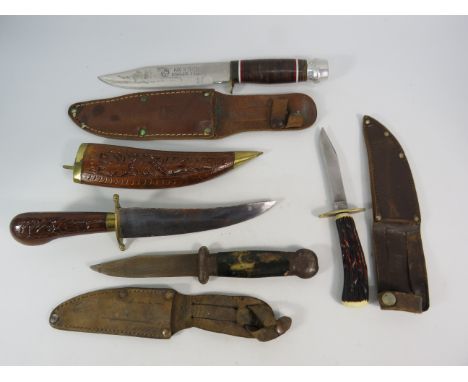 Three hunting knives in leather scabbards plus a Indian dagger in a wooden scabbard.
