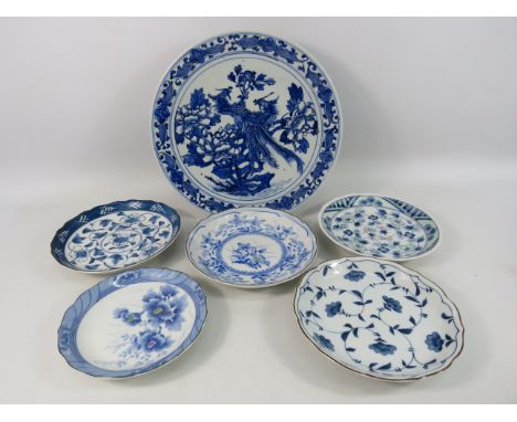 Large oriental blue and white charger decorated with birds of paradise plus five other oriental plates.