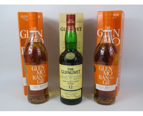 Two bottles of Glenmorangie 10 year aged whiskey with boxes and a Bottle of Glenlivet 12 year aged with box.