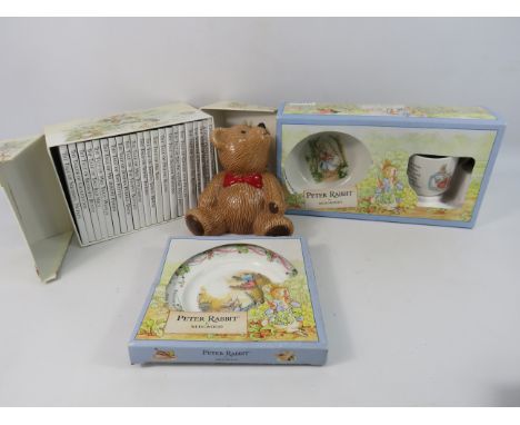 Wedgwood Peter rabbit boxed plate bowl and cup plus a set of Beatrix potter books and a teddy bear money box.