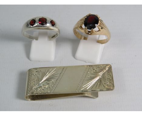 Two Mens Sterling silver garnet set rings and a sterling silver money clip, total weight 22.7 grams.