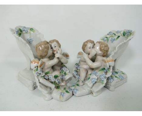 Two East German Dresden style Shoe vases with flowers and cherub decorations. Cross sword marks to base but unlikely to be Me