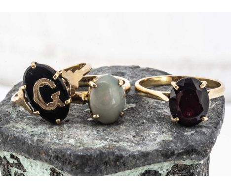 Three 9ct gold dress rings, including a garnet, an onyx signet ring, and a jade example, 7.9g