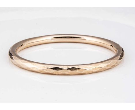 A George V 9ct gold bangle, the circular bangle with a repeating faceted top, marked Chester 1922, interior 6.8 cm exterior 8