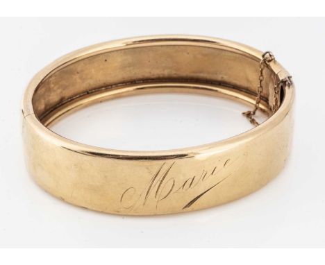 A French yellow metal hinged bangle, with engraved name Marie, clasp bearing strike marks for 18ct gold, 6.2cm x 5.4cm, 23g