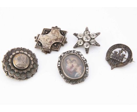 Five silver and white metal brooches,  including an oval brooch of Madonna and child marked 800, a paste set five pointed sta