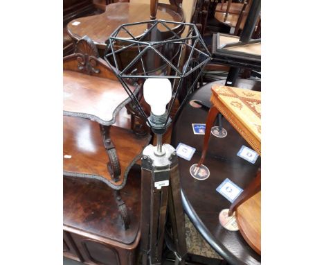 A tripod lamp with wire basket shade. 