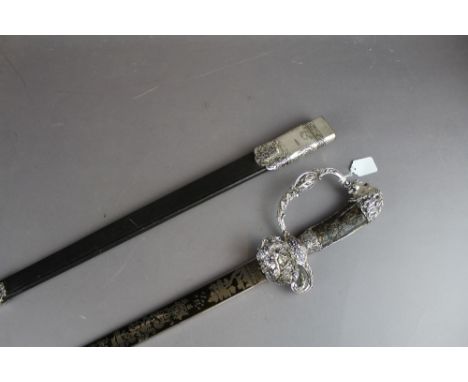 A Reproduction hunting sword having antler type handles and silver plated pommel and guards. The blade (61cm) heavily decorat