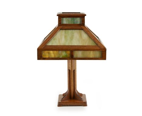 MISSION STYLE  ARTS & CRAFTS OAK AND GLASS TABLE LAMP, CIRCA 1915   the green and opaque white glass shade, raised on a squar