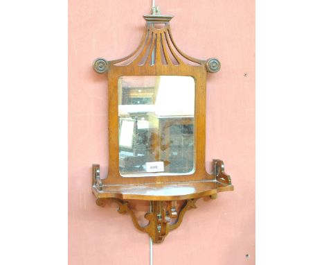 An Edwardian mahogany mirrored shelf with pierced shaped top rail, shaped platform and pierced scrolling apron, length 52cm.