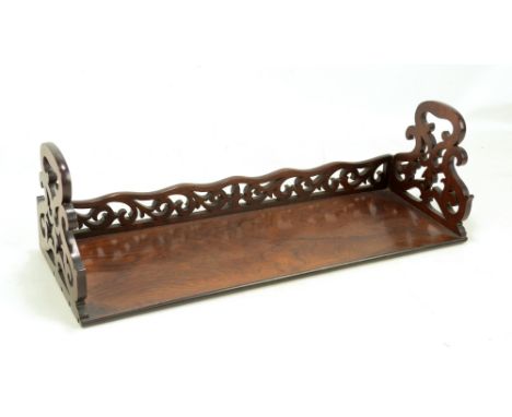 A Victorian rosewood book trough with pierced shaped ends and shaped pierced back rail with simple rectangular platform, heig