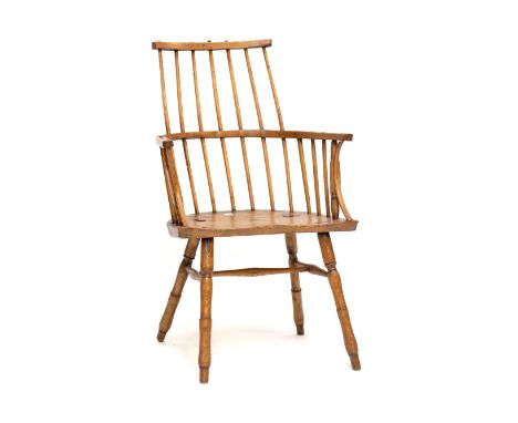 An early 19th century primitive Welsh comb stick back elbow chair, in ash and elm, with saddle seat and turned outsplayed leg