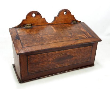 A late George III oak and mahogany crossbanded candle box, the double arched back plate above hinged lid with lozenge shaped 