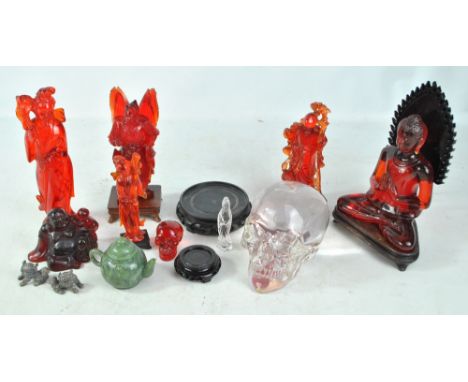 A group of resin Oriental figures to include a seated Buddha and a warrior, also two models of skulls and a green hardstone t