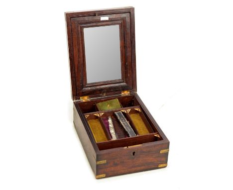 A 19th century teak and brass bound gentleman's travelling box, the hinged lid set with a folding mirror above an interior wi