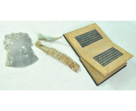 A group of green hardstone plaques with archaic-style printed script presented in a book, a carved pipe modelled as a mythica
