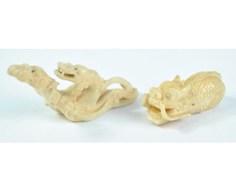 A late 19th/early 20th century Chinese ivory carving depicting two dragon heads amongst clouds, length 8cm, and a Japanese Me