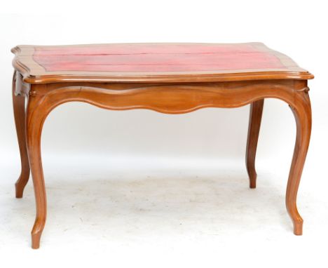 A circa 1900 French walnut centre table of serpentine outline, with gilt tooled red leather inset central panel raised on fou