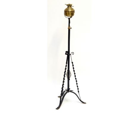 A brass and wrought iron adjustable oil lamp converted to electricity, with opaque glass shade and wrythen twisted uprights.