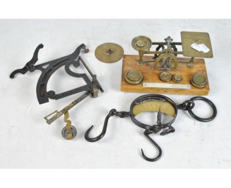 A set of postal scales with eight weights, a further table top scale and a hanging scale.