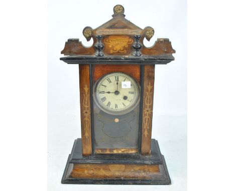 A thirty hour inlaid mantel clock with carved pediment on rectangular base, the circular dial set with Roman numerals, height