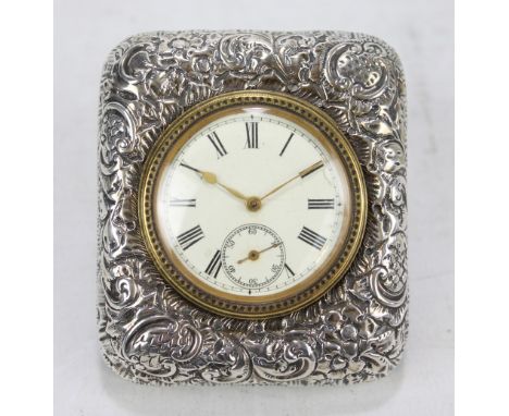 DOUGLAS CLOCK CO; a Victorian hallmarked silver fronted travel clock with foliate scroll decoration, the circular dial set wi