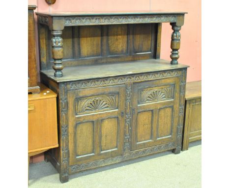 A reproduction oak court cupboard with open shelf above two cupboard doors, width approx 125cm.