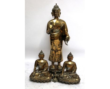 A large freestanding hollow cast brass Buddha on lotus base, height approx 132cm, a further pair of 20th century brass Buddha