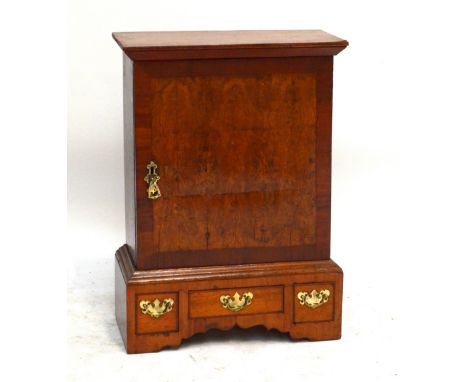 An 18th century oak, pollard oak and mahogany crossbanded table top cabinet with single door enclosing four pigeon holes abov