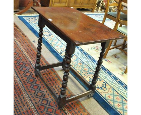 An 18th century oak plank top occasional table with bobbin turned and block supports, height 71cm, length 73cm, width 44cm.