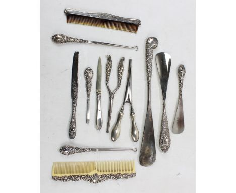 A group of variously hallmarked silver handled dressing items comprising three shoe horns, the largest length 31cm, a near pa