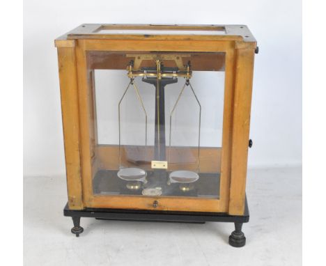A cased set of scales by Stanton of London in glazed display case on rectangular stand. 