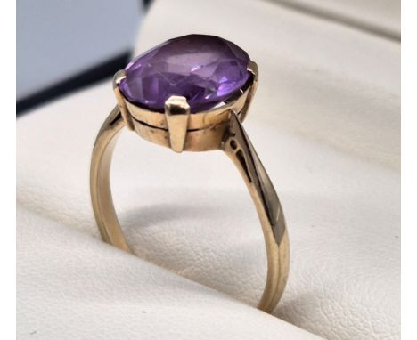 9ct yellow gold ladies ring set with a single oval cut purple sapphire. [Ring size- q] [2.71grams] [Sapphire- 12x9x4mm] 