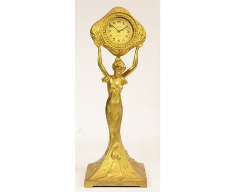 An Art Deco style figural table clock, the gilt spelter of a lady holding a clock a loft, the 8 day jewelled movement made in