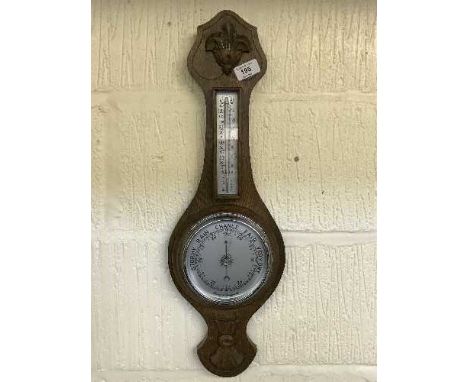 A carved oak aneroid barometer/thermometer