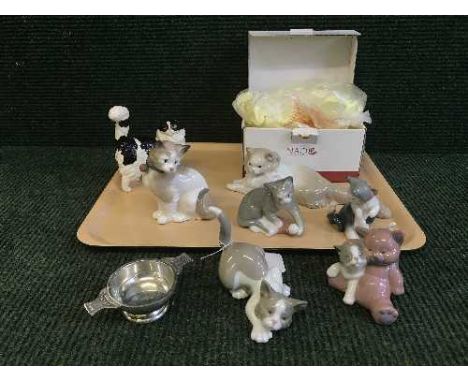 A collection of seven Nao and Lladro cats, one boxed, a Doulton cat and a silver plated quaich