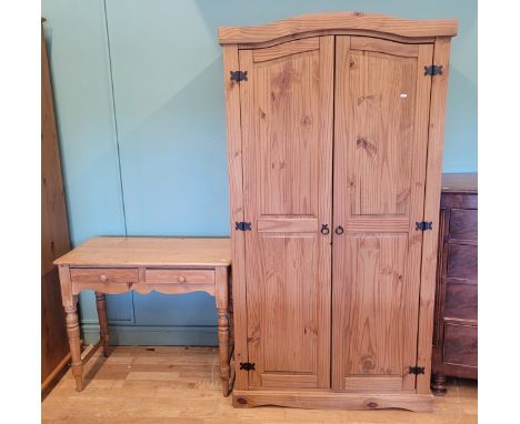 A contemporary pine single wardrobe, having shaped twin doors opening to fitted clothes rail and shelf, raised on a shaped pl